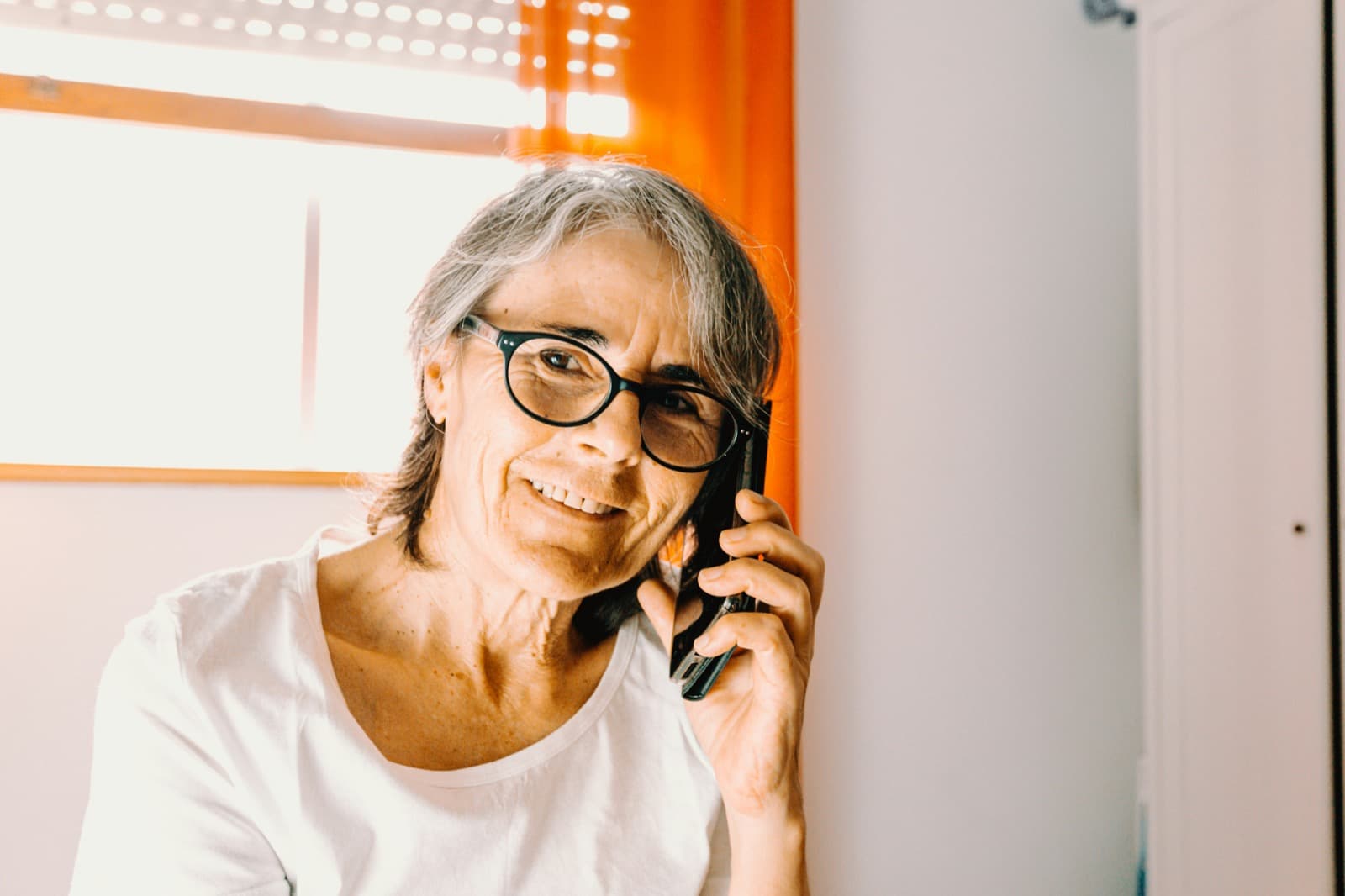 A woman smiling warmly during a phone call